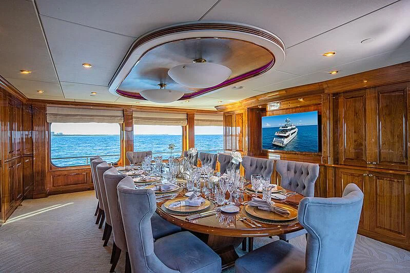 a dining room with a large chandelier aboard AMORE Yacht for Charter