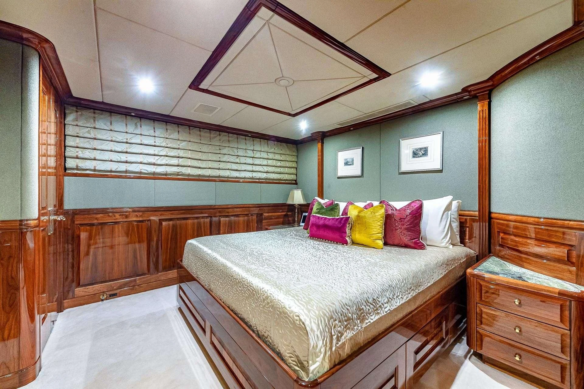a bedroom with a bed and a wood wall aboard AMORE Yacht for Charter