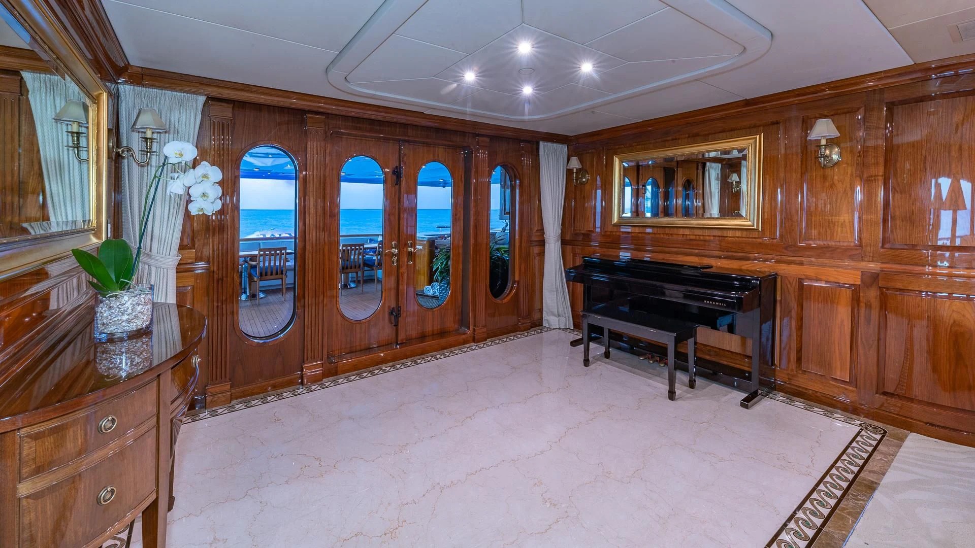 a large room with a piano and wooden cabinets aboard AMORE Yacht for Charter