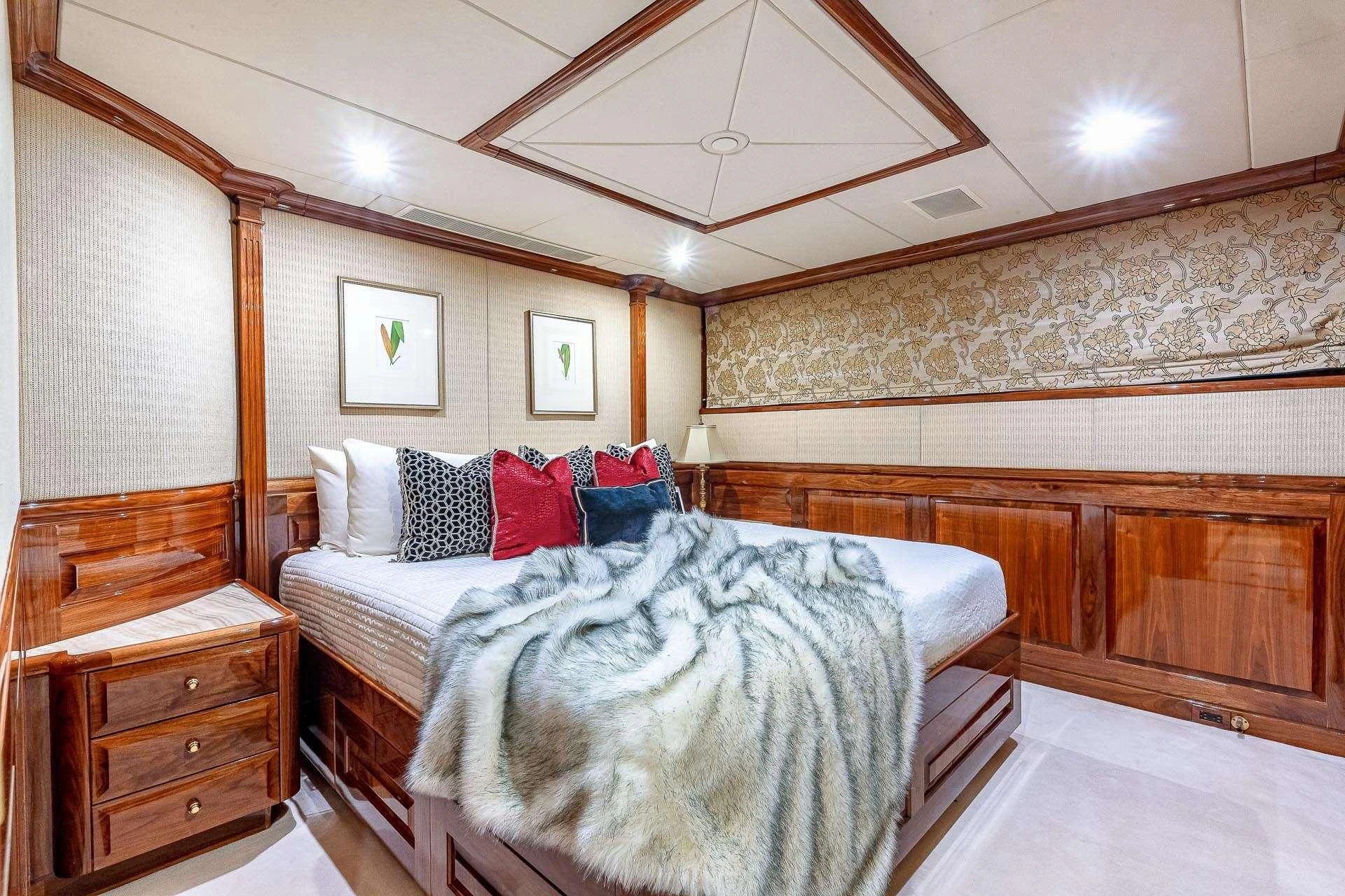 a bedroom with a bed and a dresser aboard AMORE Yacht for Charter
