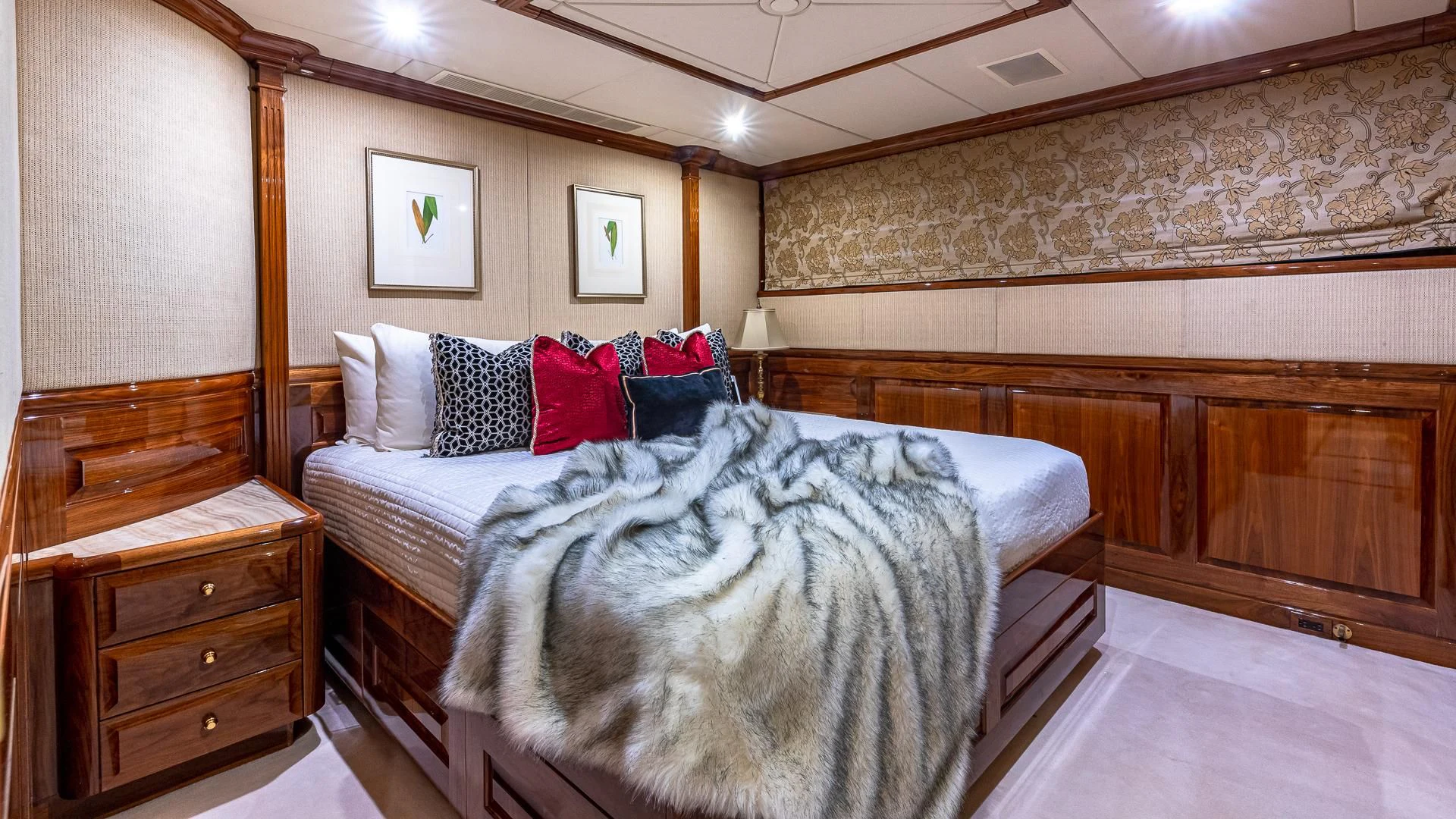 a room with a bed and a dresser aboard AMORE Yacht for Charter