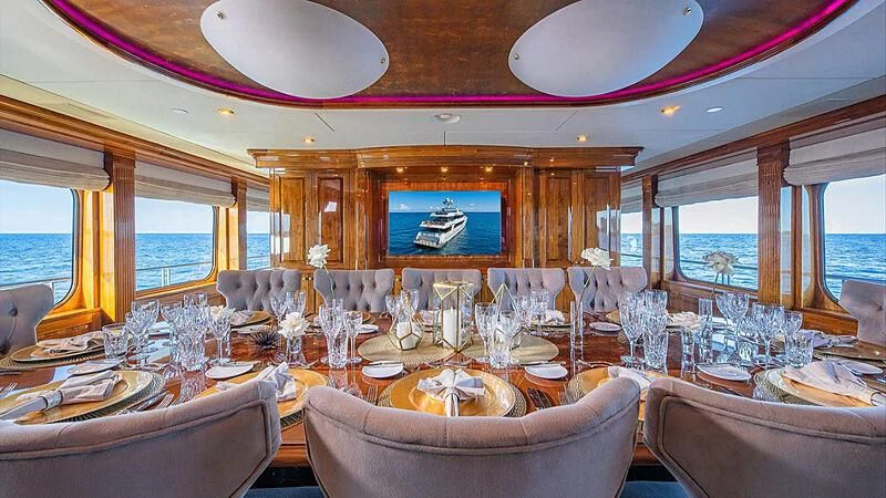 a dining room with a large screen aboard AMORE Yacht for Charter