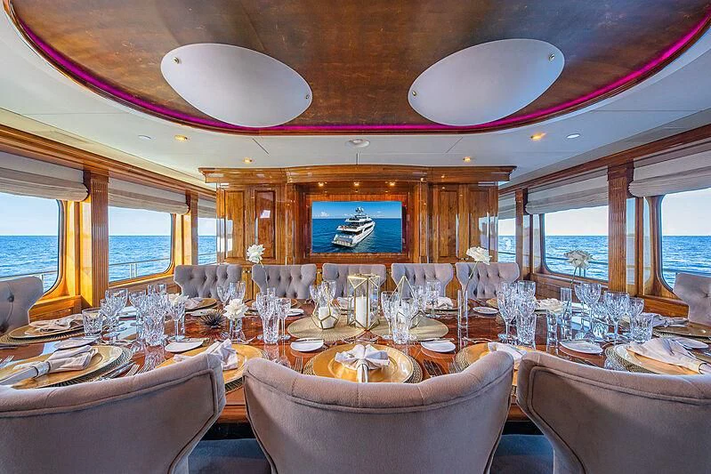 a dining room with a chandelier aboard AMORE Yacht for Charter