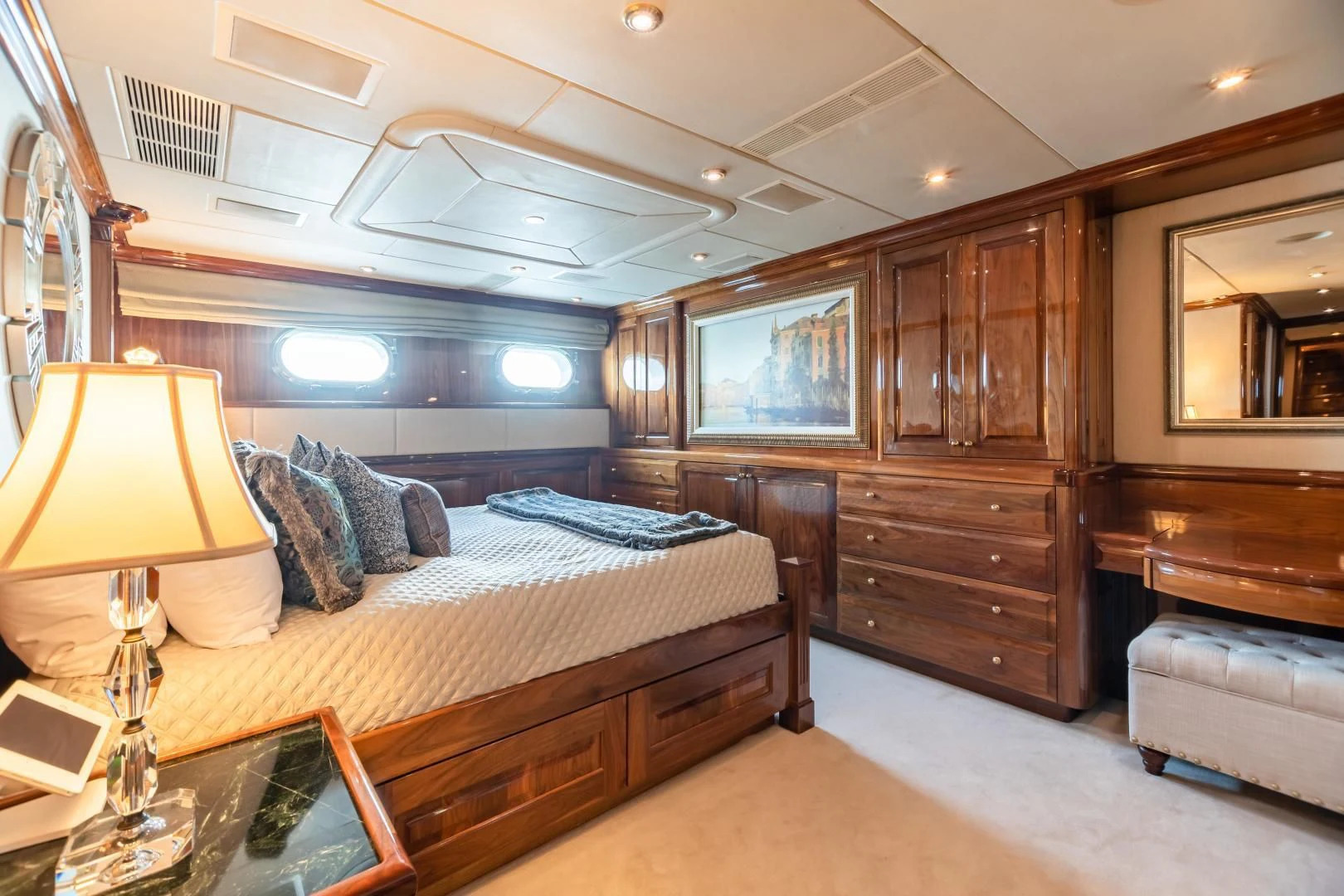 a bedroom with a bed and a wood cabinet aboard AMORE Yacht for Charter