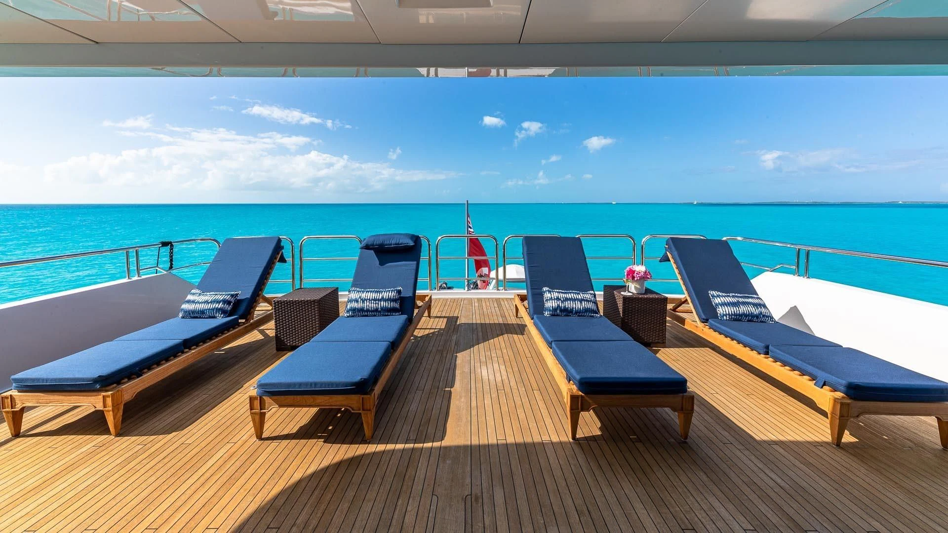 a deck with chairs and tables on it by the water aboard AMORE Yacht for Charter