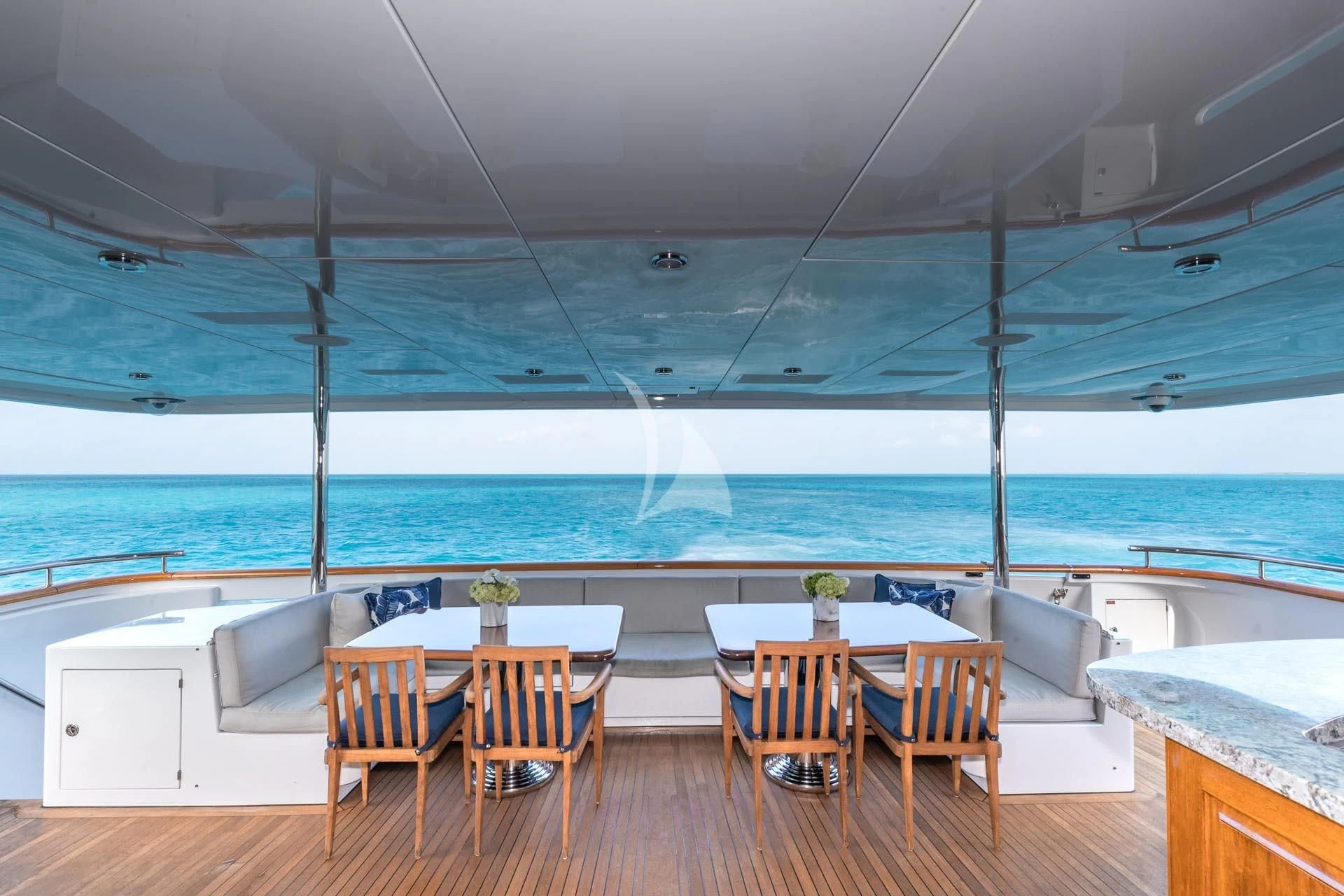 a room with a table and chairs and a large body of water aboard AMORE Yacht for Charter