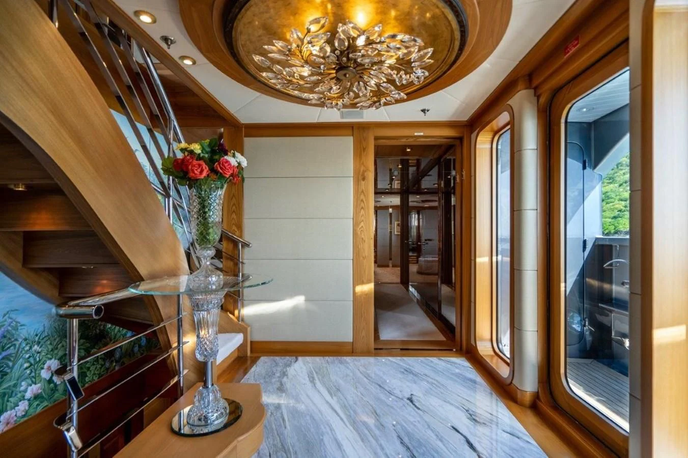 a large ornate chandelier hangs from a chandelier aboard VIBRANCE Yacht for Sale