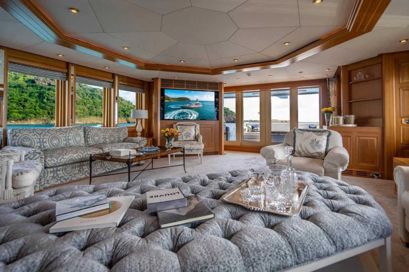 a living room with a large leather couch and a large screen tv aboard VIBRANCE Yacht for Sale