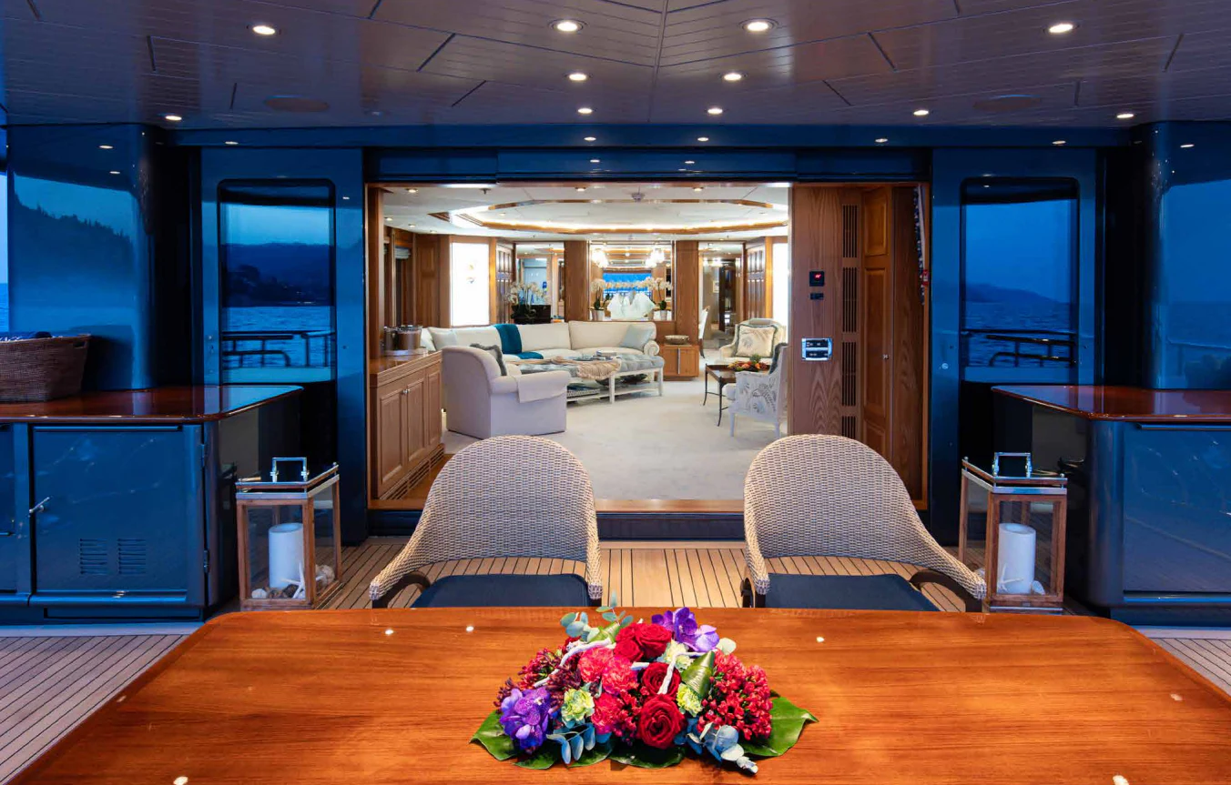 a room with a table chairs and a tv aboard VIBRANCE Yacht for Sale