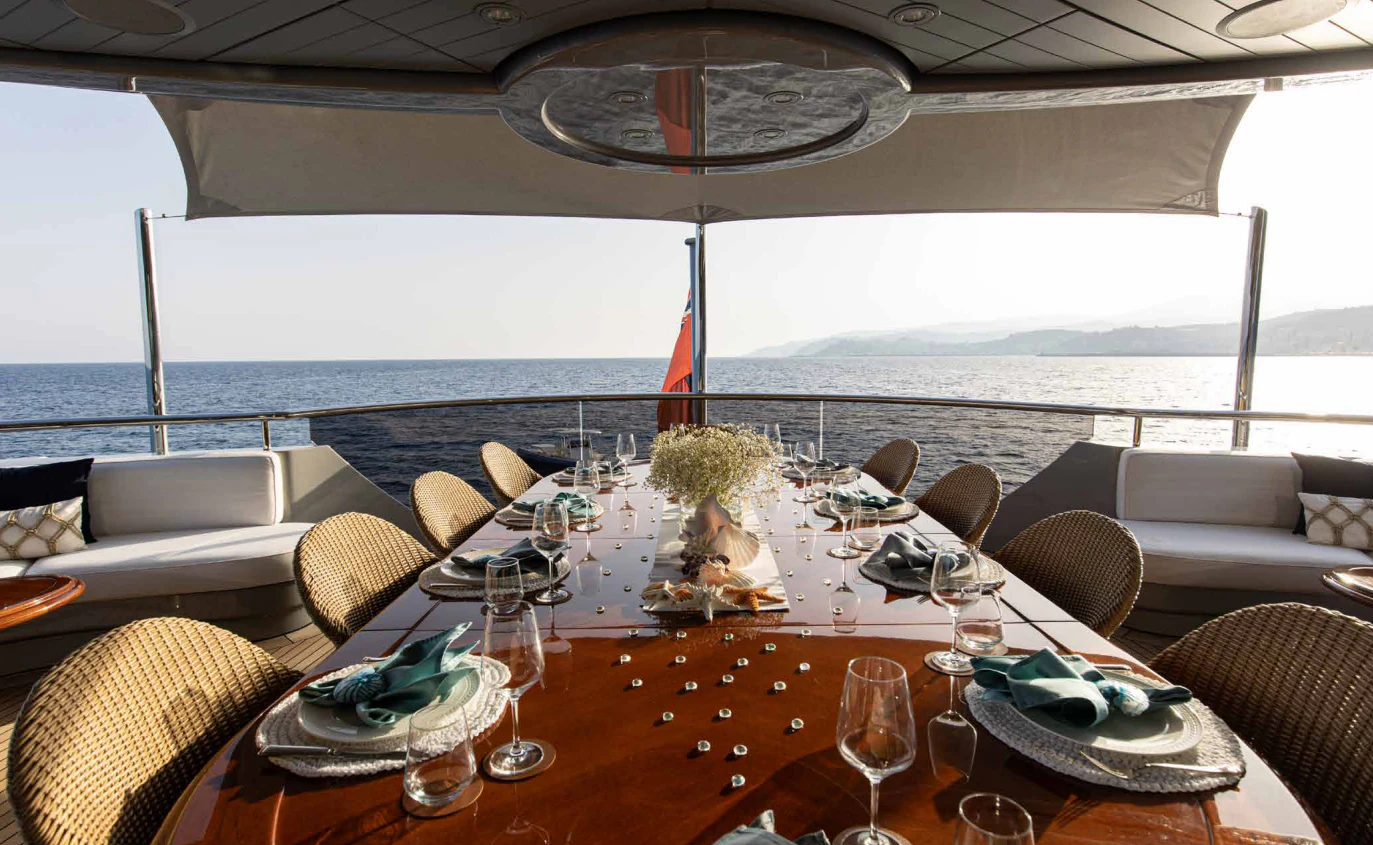 a table with chairs and a large white tent with a view of the ocean aboard VIBRANCE Yacht for Sale