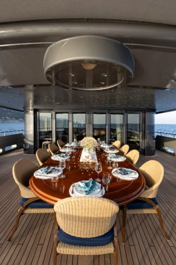 a dining room table with a chandelier above it aboard VIBRANCE Yacht for Sale