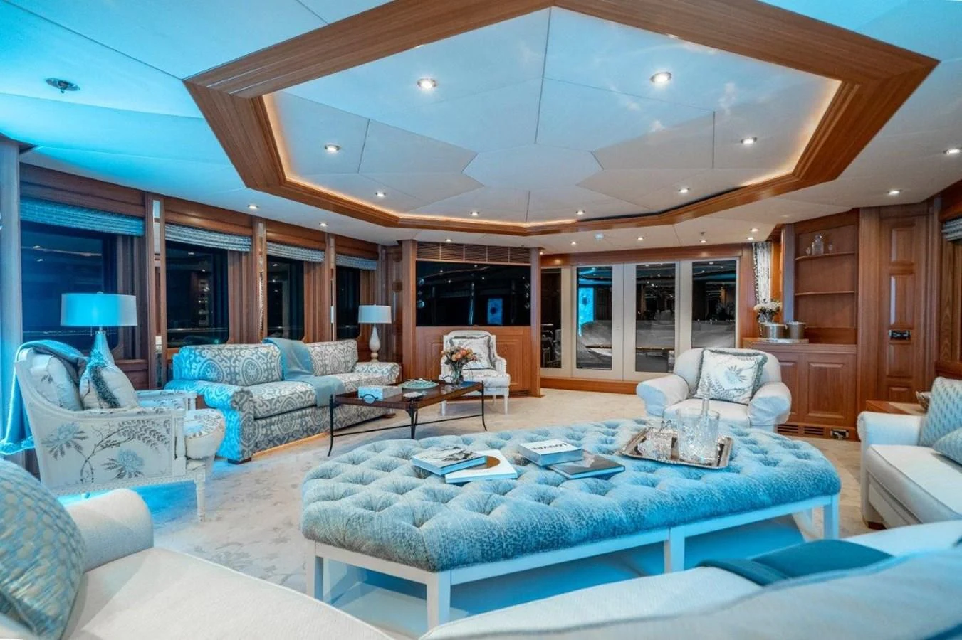 a large living room with a large blue couch and a large open door aboard VIBRANCE Yacht for Sale
