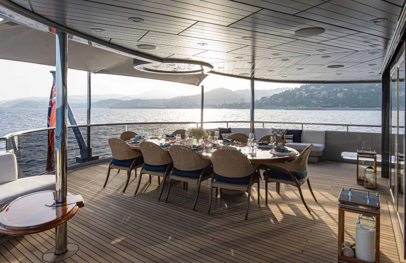 a large dining table on a deck aboard VIBRANCE Yacht for Sale