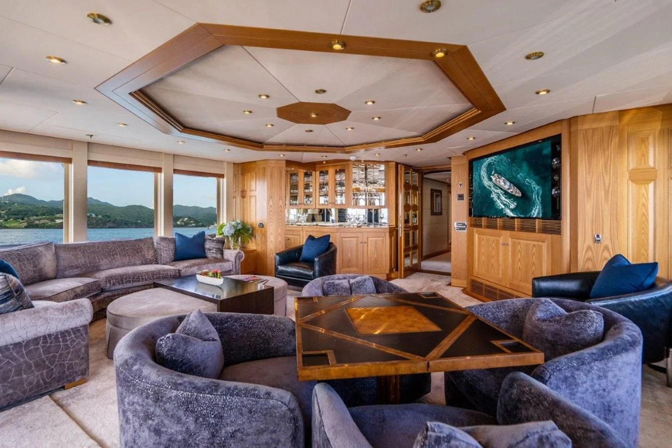 a living room with leather couches and a tv aboard VIBRANCE Yacht for Sale