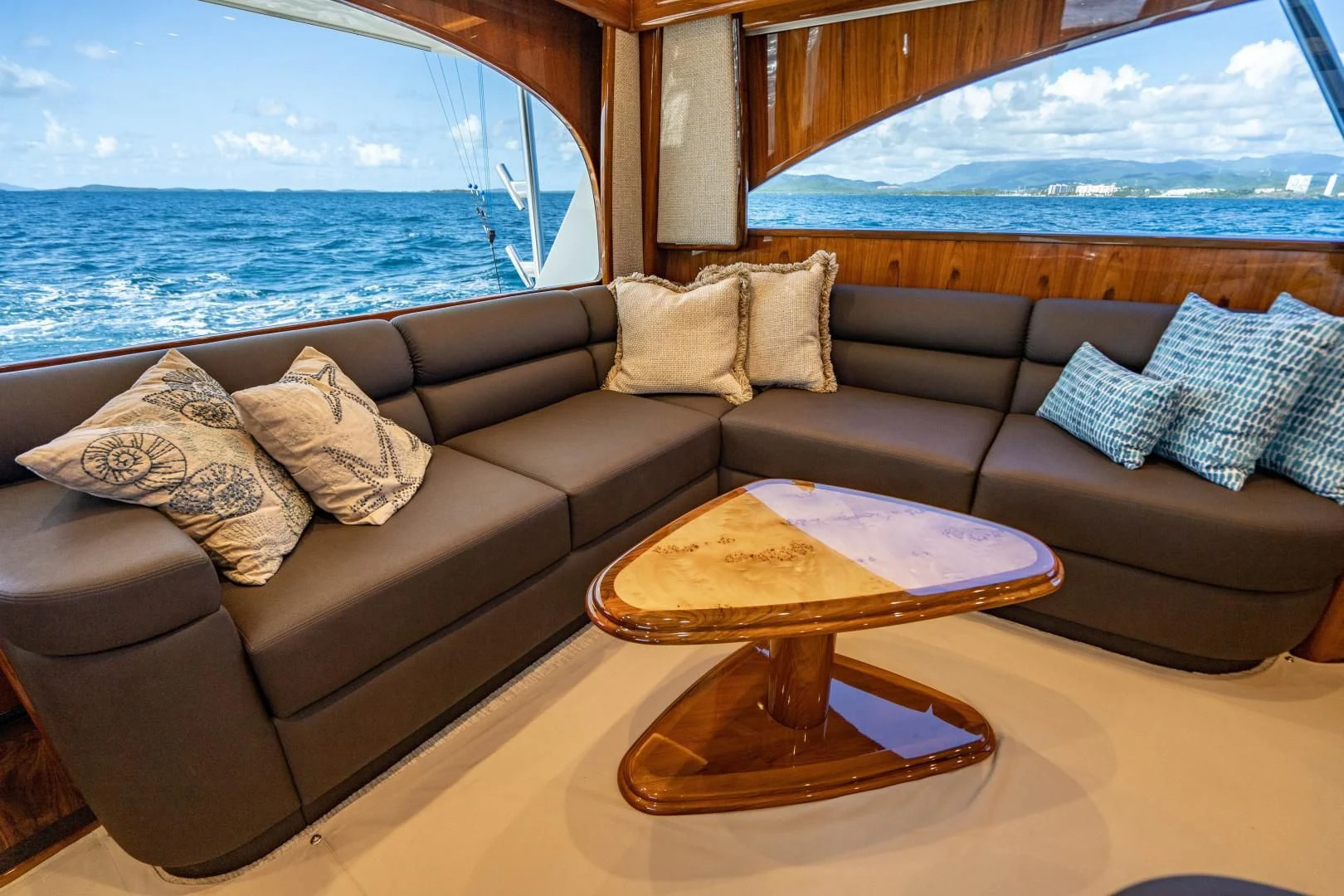 a couch with pillows and a table aboard PLAN B Yacht for Sale