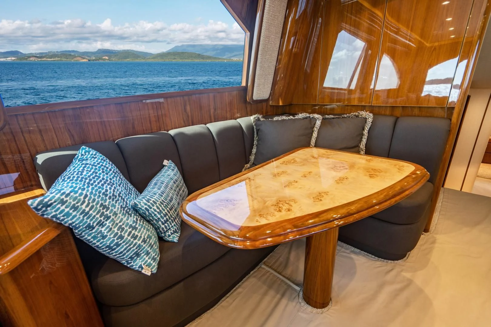 a couch with pillows and a table aboard PLAN B Yacht for Sale