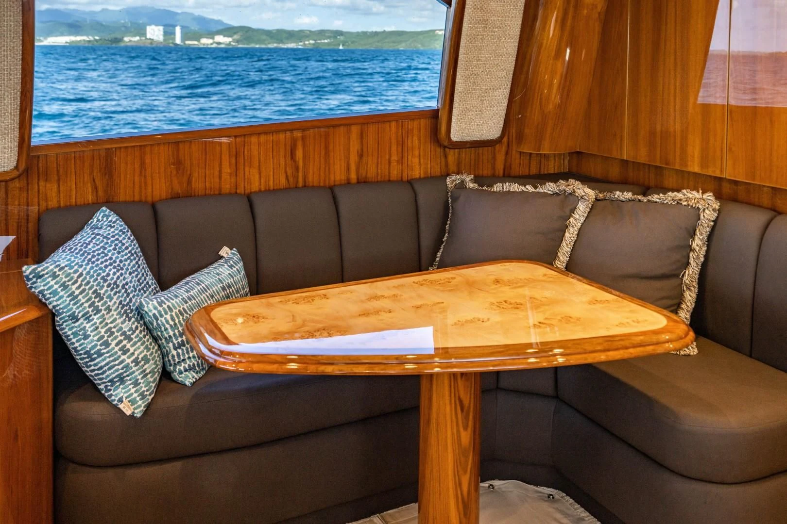 a couch with pillows and a table aboard PLAN B Yacht for Sale