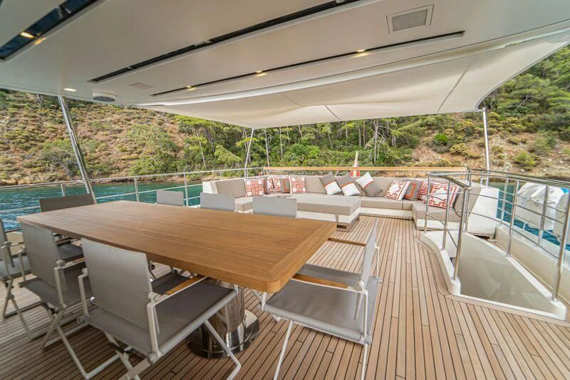 a deck with a table and chairs on it aboard SOUTH SEA Yacht for Sale