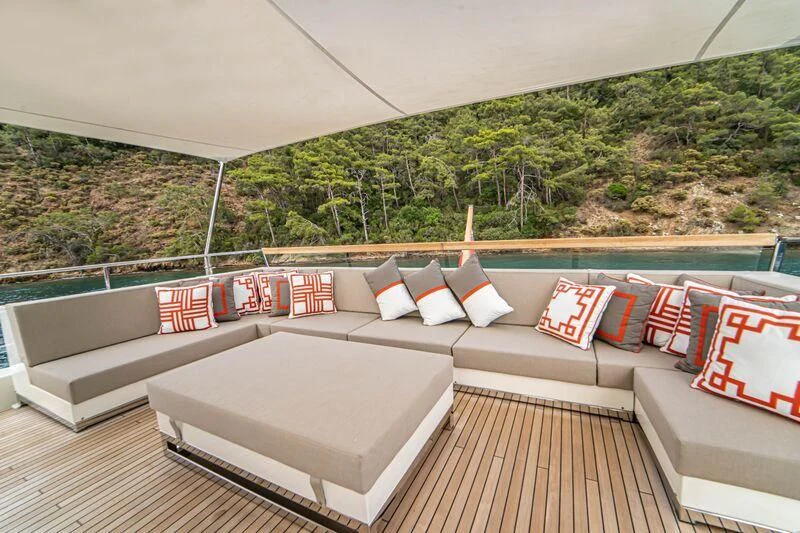 a large white couch with pillows on a deck overlooking a city aboard SOUTH SEA Yacht for Sale