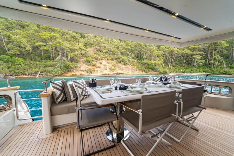 a table and chairs on a deck overlooking a lake aboard SOUTH SEA Yacht for Sale
