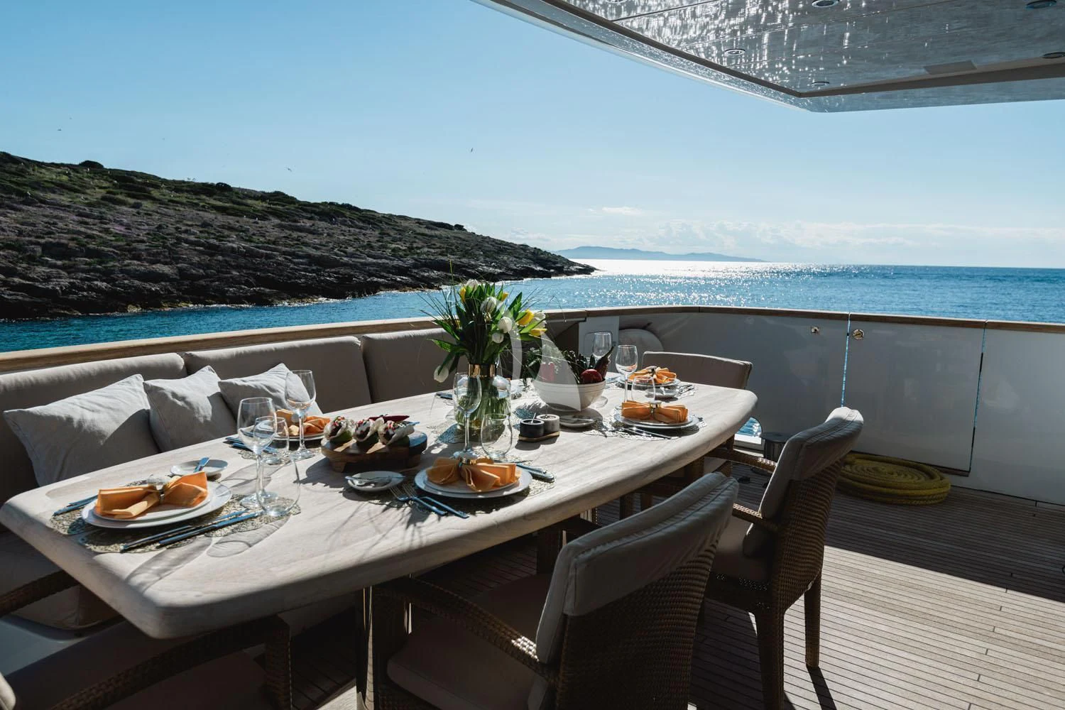 a table set for a meal on a deck overlooking the ocean aboard LOANA Yacht for Sale