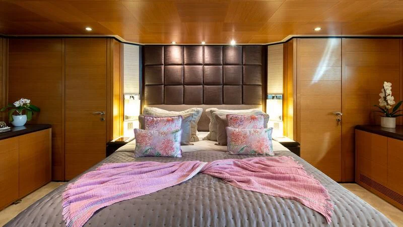 a bed with purple sheets aboard LOANA Yacht for Sale