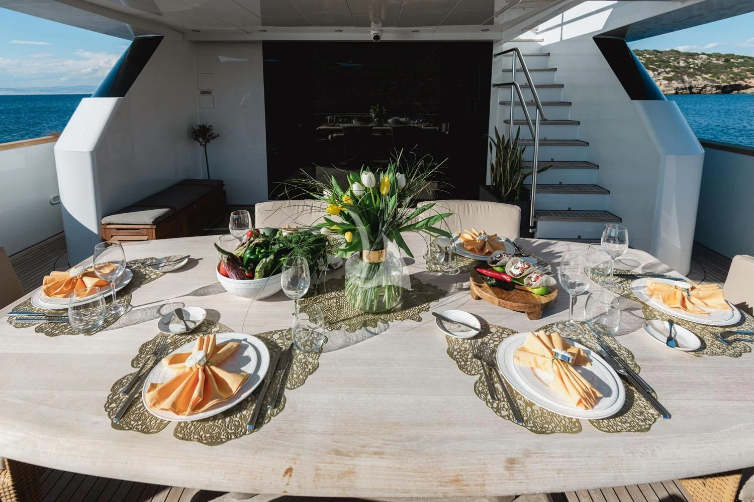 a table with plates and glasses aboard LOANA Yacht for Sale