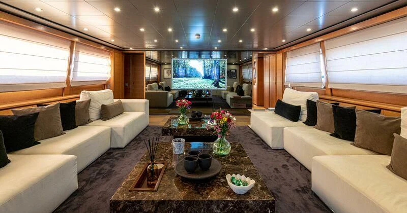 a living room with a large screen aboard LOANA Yacht for Sale
