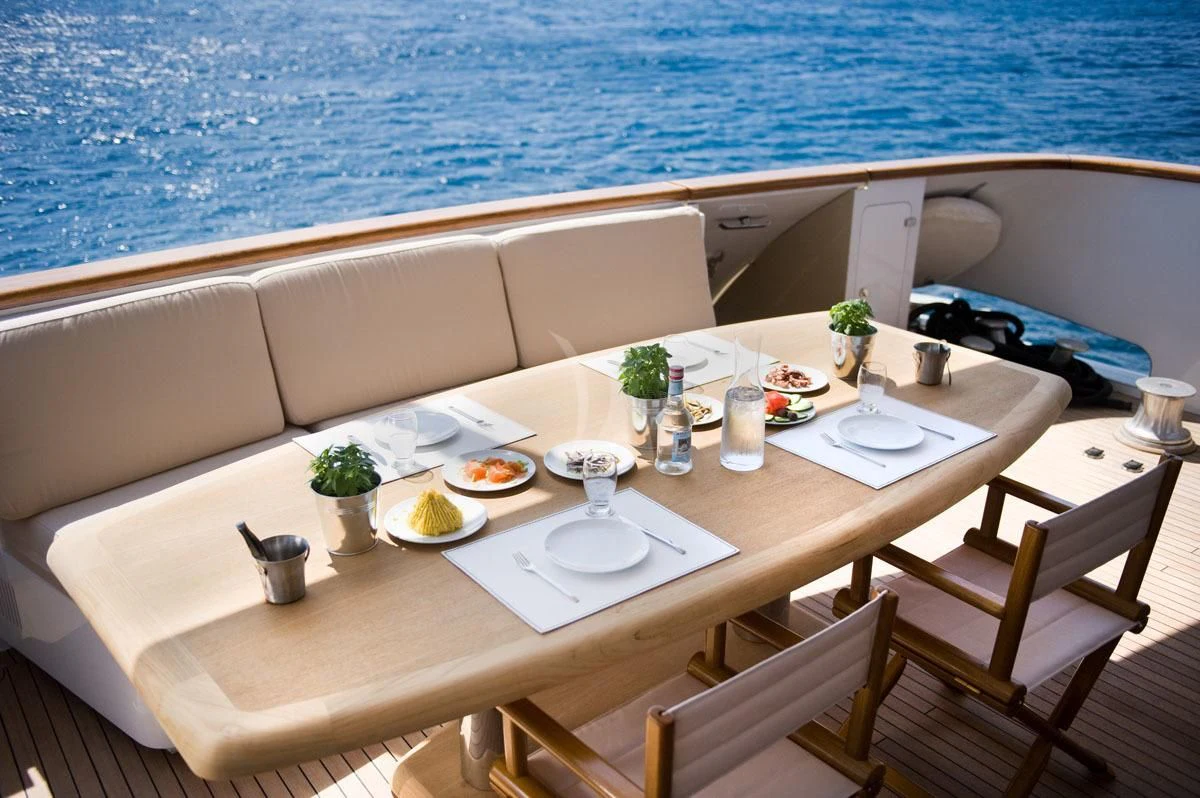 a table with plates and glasses on it aboard LOANA Yacht for Sale