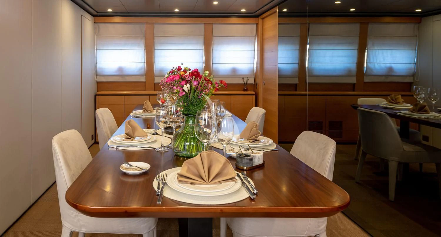 a table with plates and glasses on it aboard LOANA Yacht for Sale