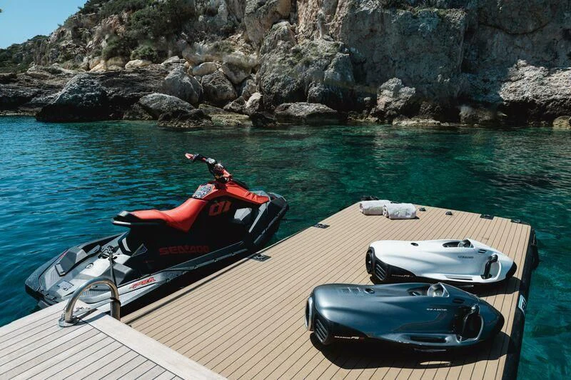 a boat and a motorbike on a dock aboard LOANA Yacht for Sale