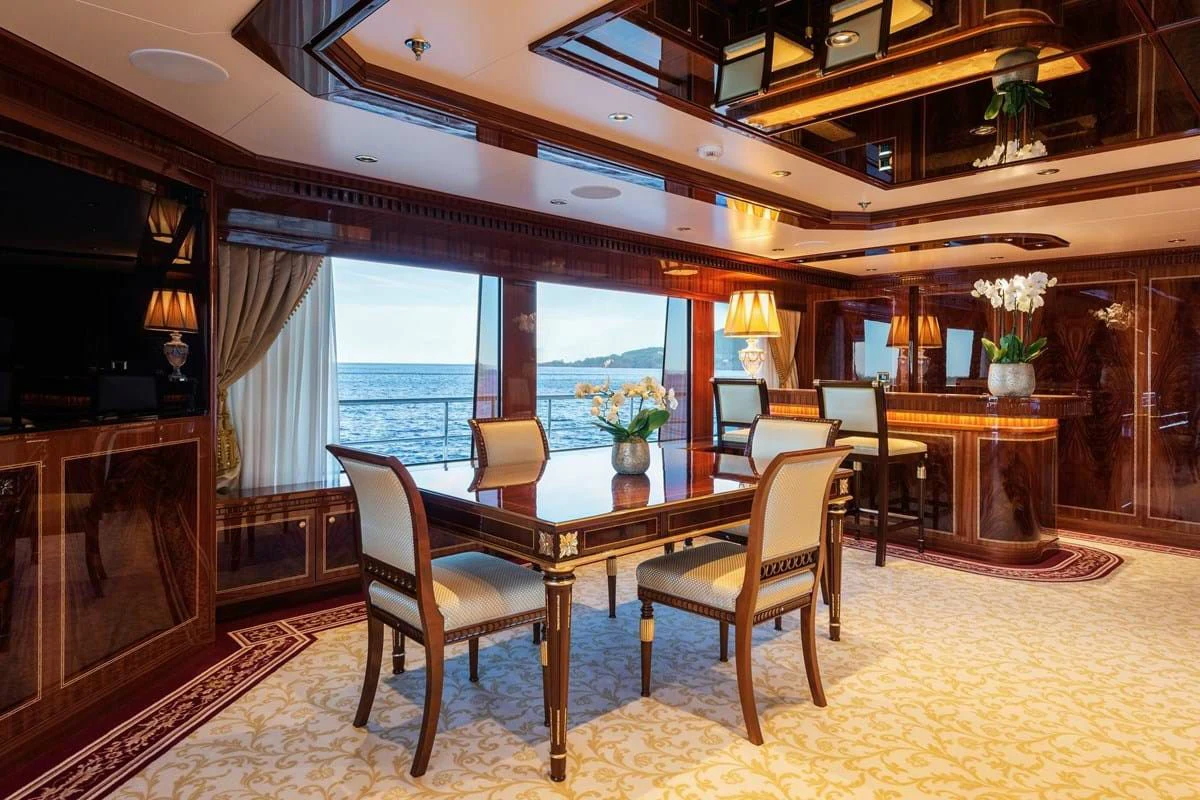 a dining room with a table and chairs aboard COCKTAILS Yacht for Sale