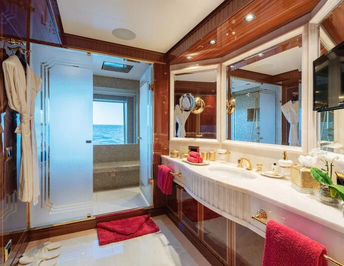 a bathroom with a tub sink and mirror aboard COCKTAILS Yacht for Sale