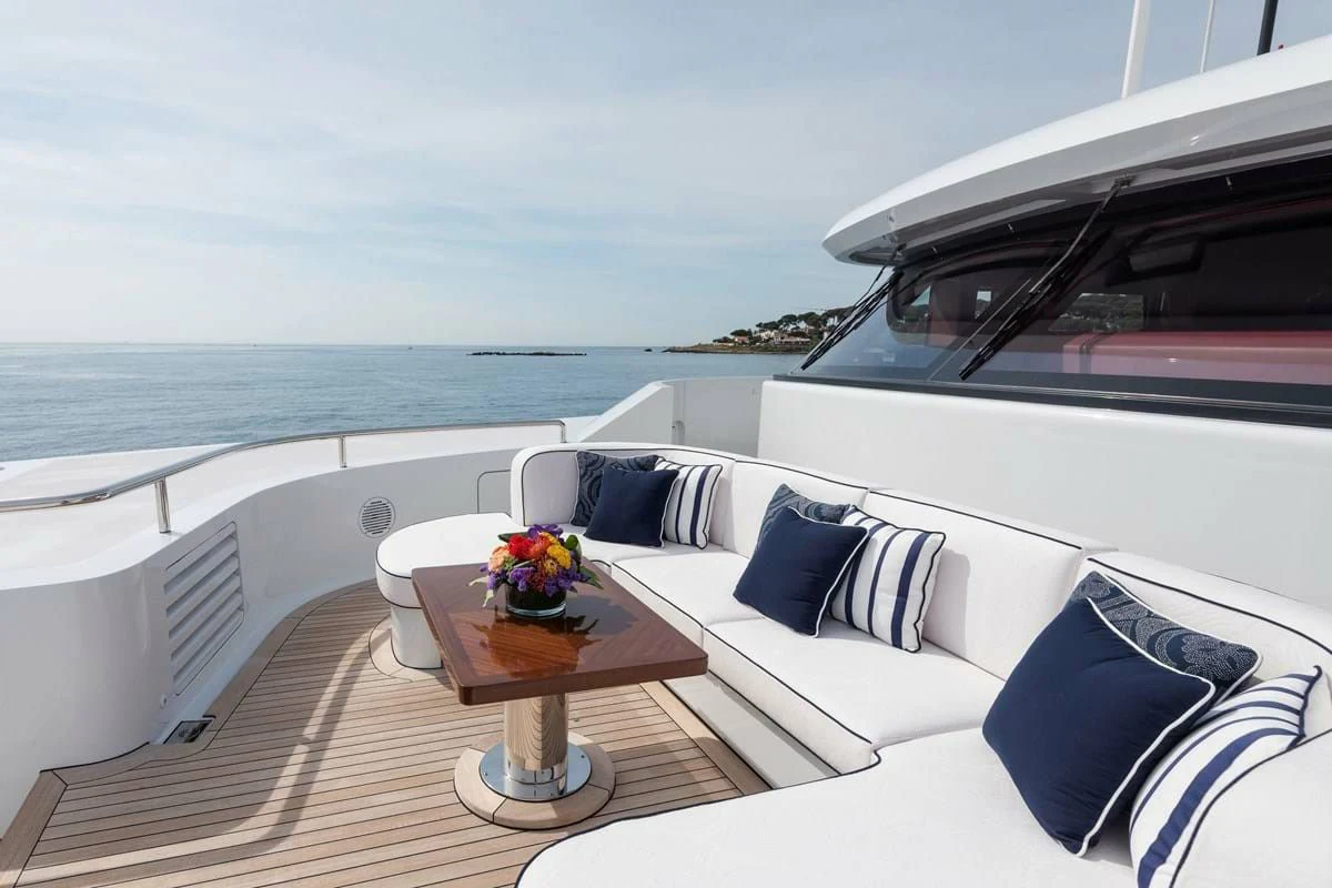 a white couch on a deck overlooking the ocean aboard COCKTAILS Yacht for Sale