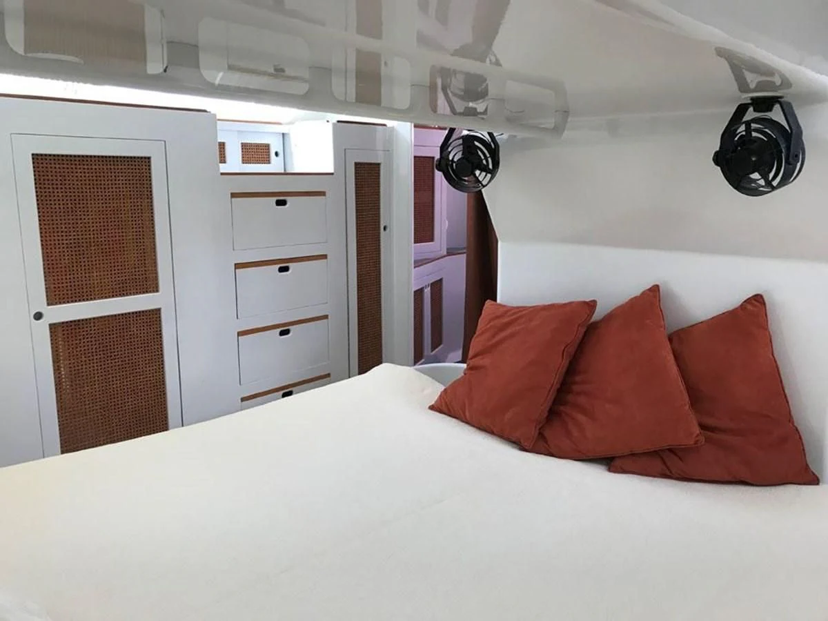 a white bed with red pillows aboard ROUTE 66 Yacht for Sale