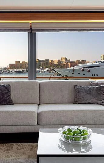 a couch and a table in front of a window overlooking a city aboard MIRA 1 Yacht for Sale