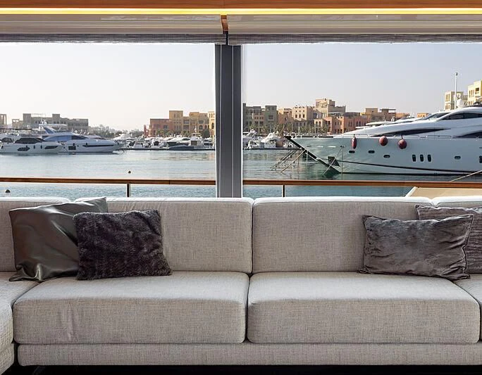 a couch and a window overlooking a body of water aboard MIRA 1 Yacht for Sale
