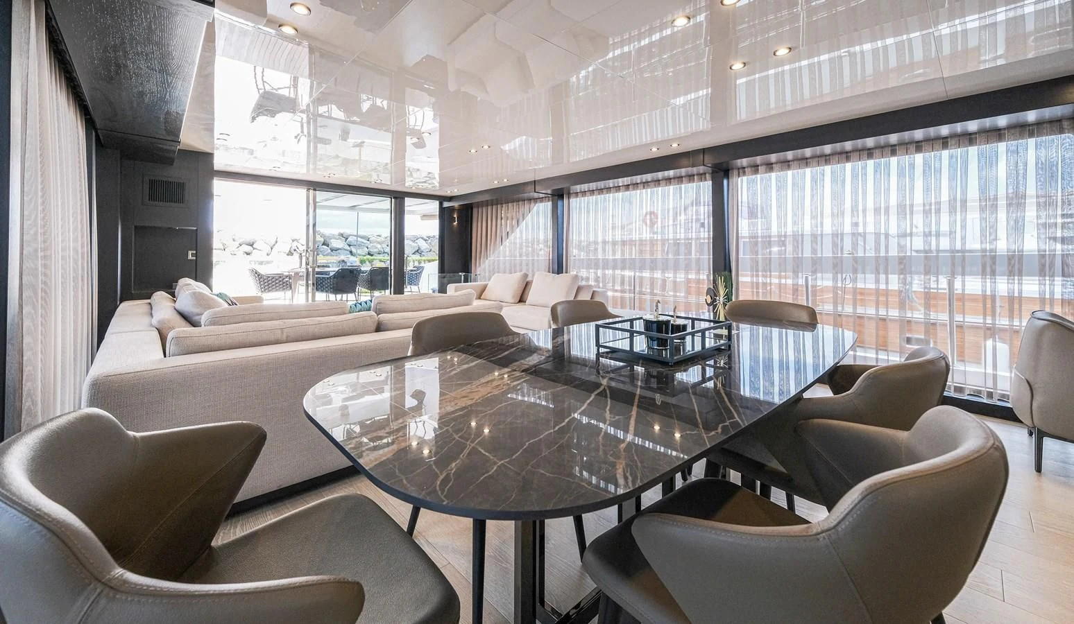 a large living room with a large glass table and chairs aboard ONYX 87/01 Yacht for Sale