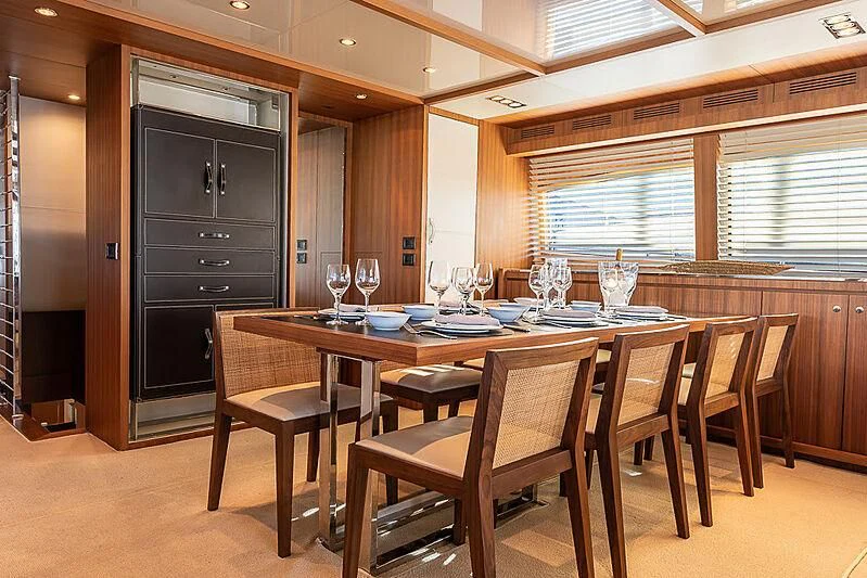 a dining table and chairs in a room with wood walls aboard REFLECT Yacht for Sale