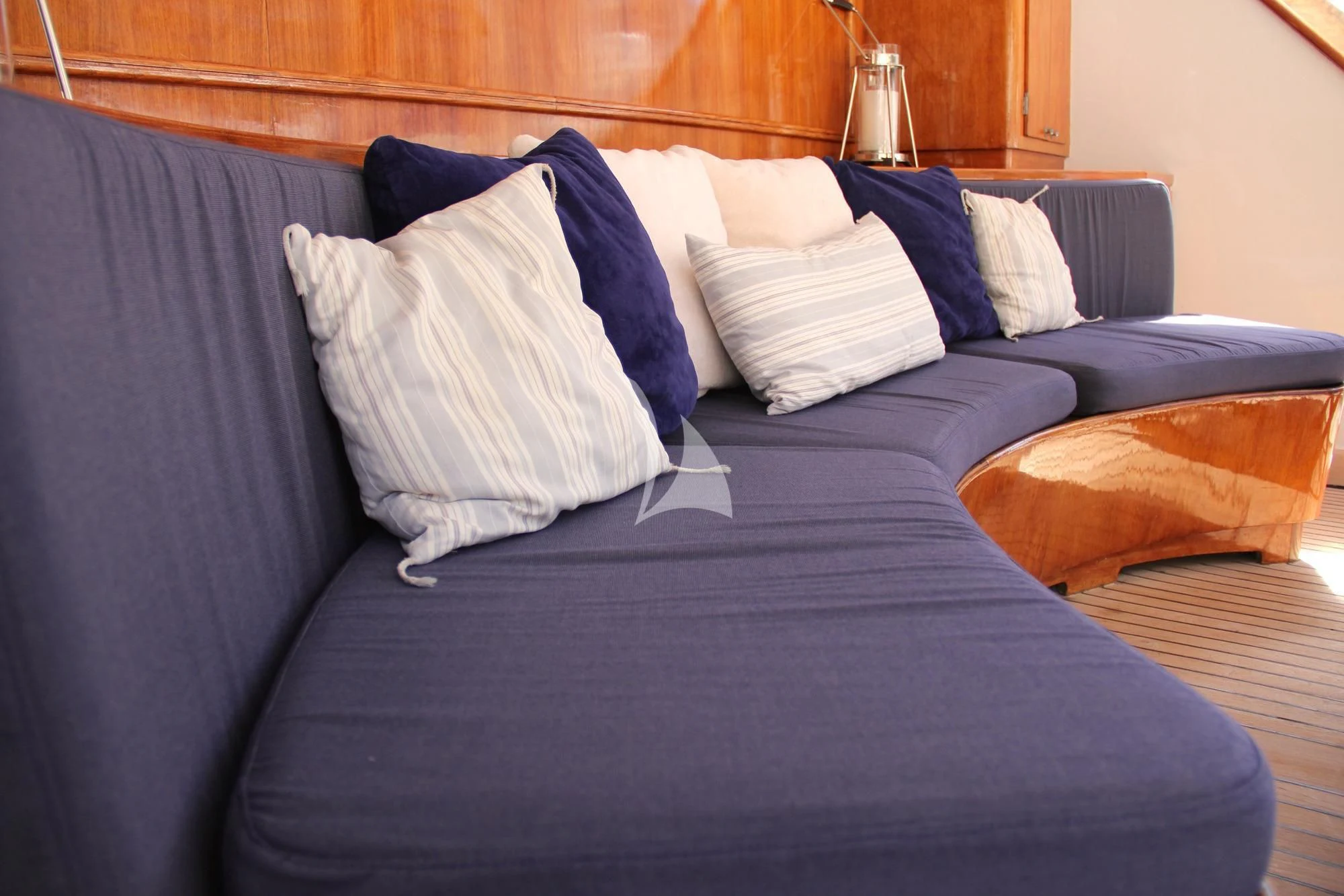 a bed with blue pillows aboard AVA Yacht for Charter