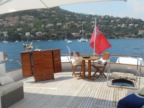 a deck with chairs and an umbrella aboard AVA Yacht for Charter