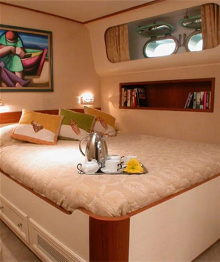 a bed with a tea kettle on it and a tea kettle on the side aboard AVA Yacht for Charter
