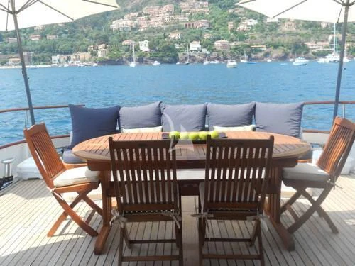 a table and chairs on a balcony aboard AVA Yacht for Charter