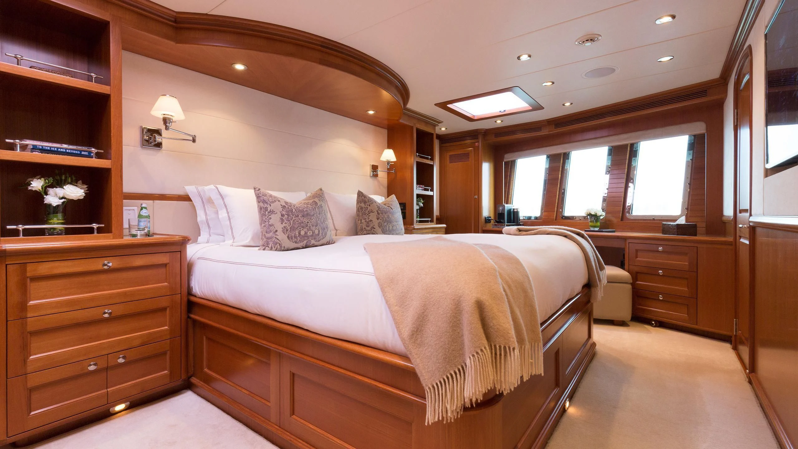 a bedroom with a bed and a dresser aboard SOLACE Yacht for Sale