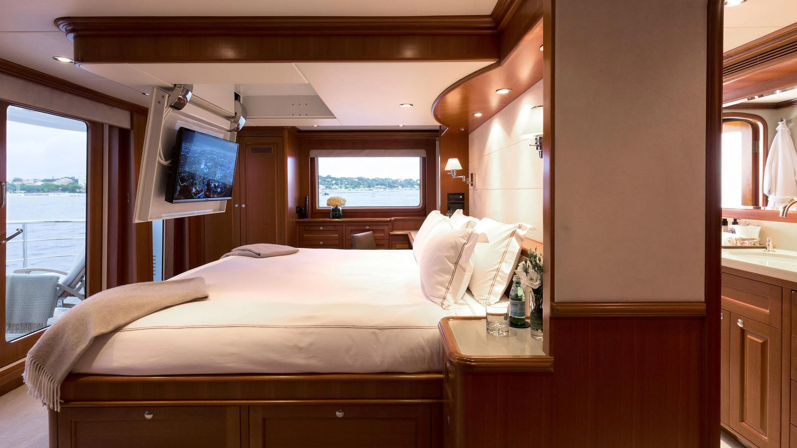 a bedroom with a bed and a tv on the wall aboard SOLACE Yacht for Sale