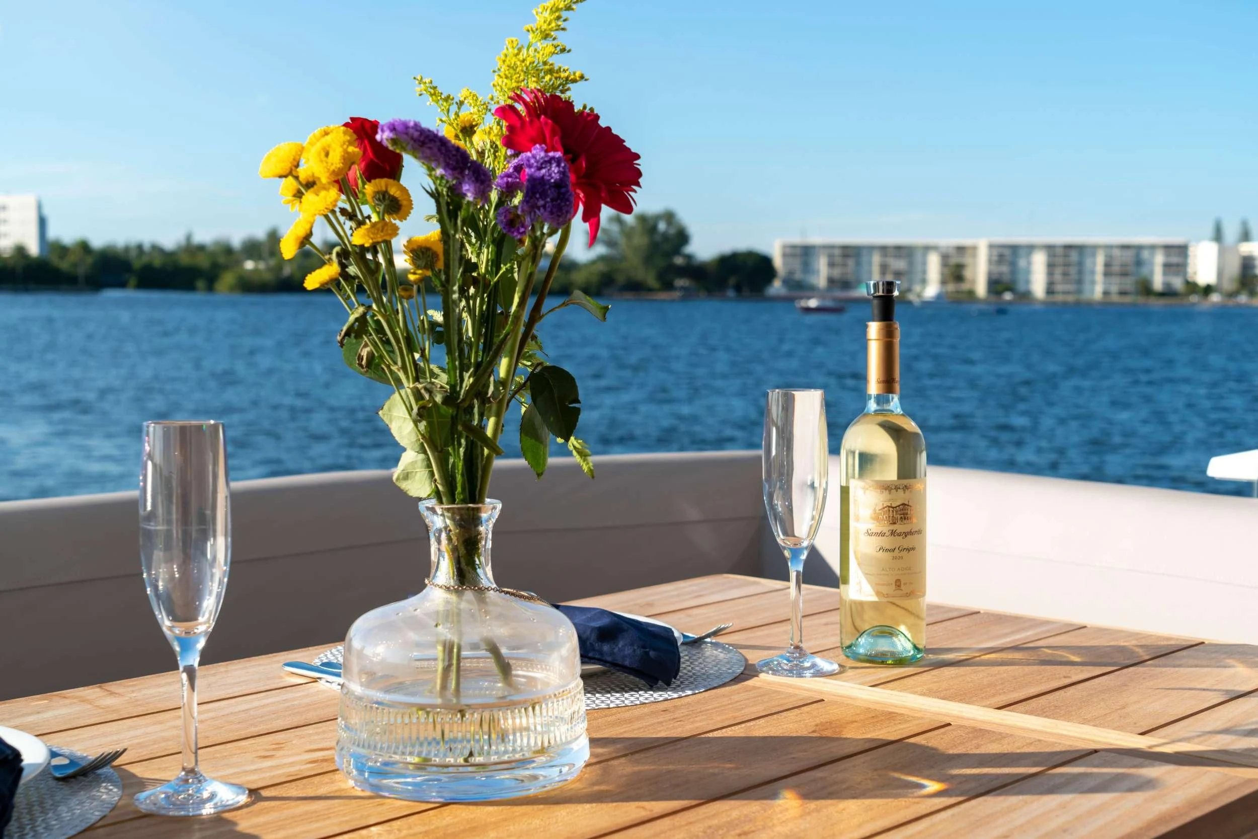 a table with wine glasses and flowers aboard MILAMO Yacht for Sale
