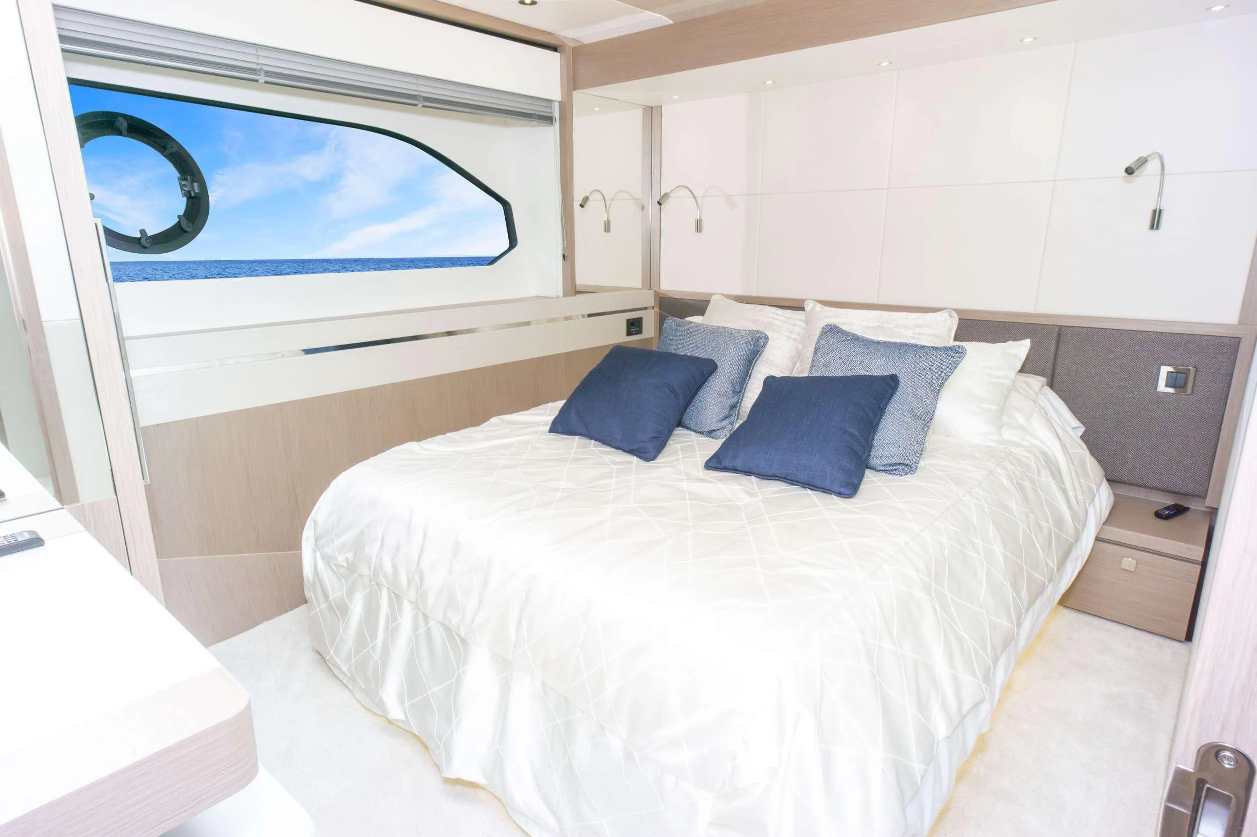 a bed with blue pillows aboard MILAMO Yacht for Sale