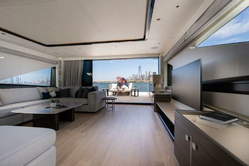 a room with a large screen tv and a table with chairs aboard WORTH THE WAIT Yacht for Sale