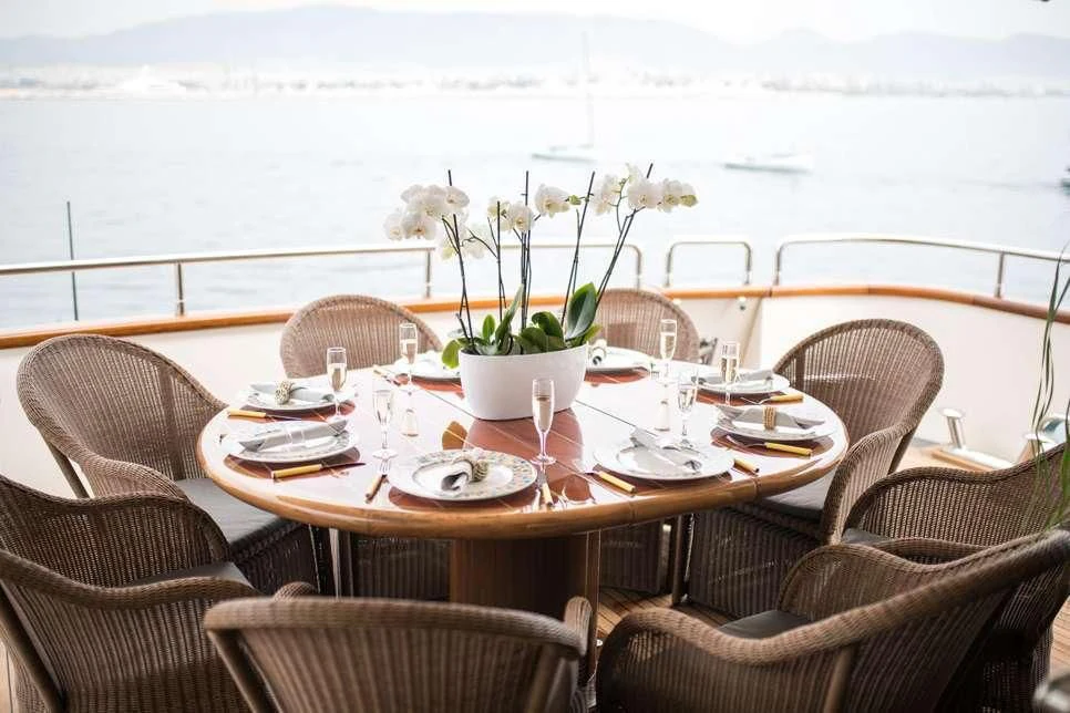 a table with plates and flowers on it aboard STAR LINK Yacht for Sale