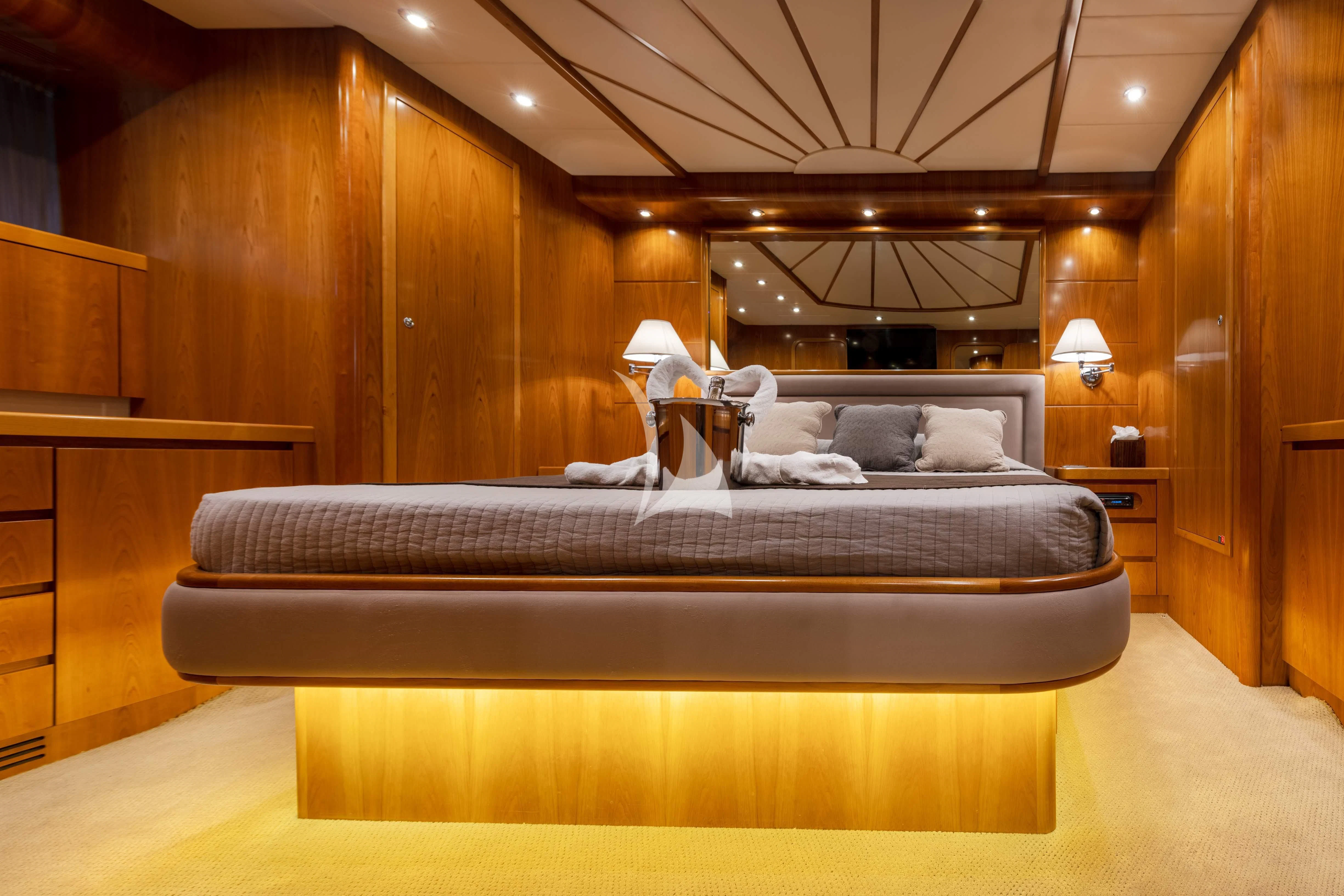 a bed with a couple of lamps on either side of it aboard STAR LINK Yacht for Sale